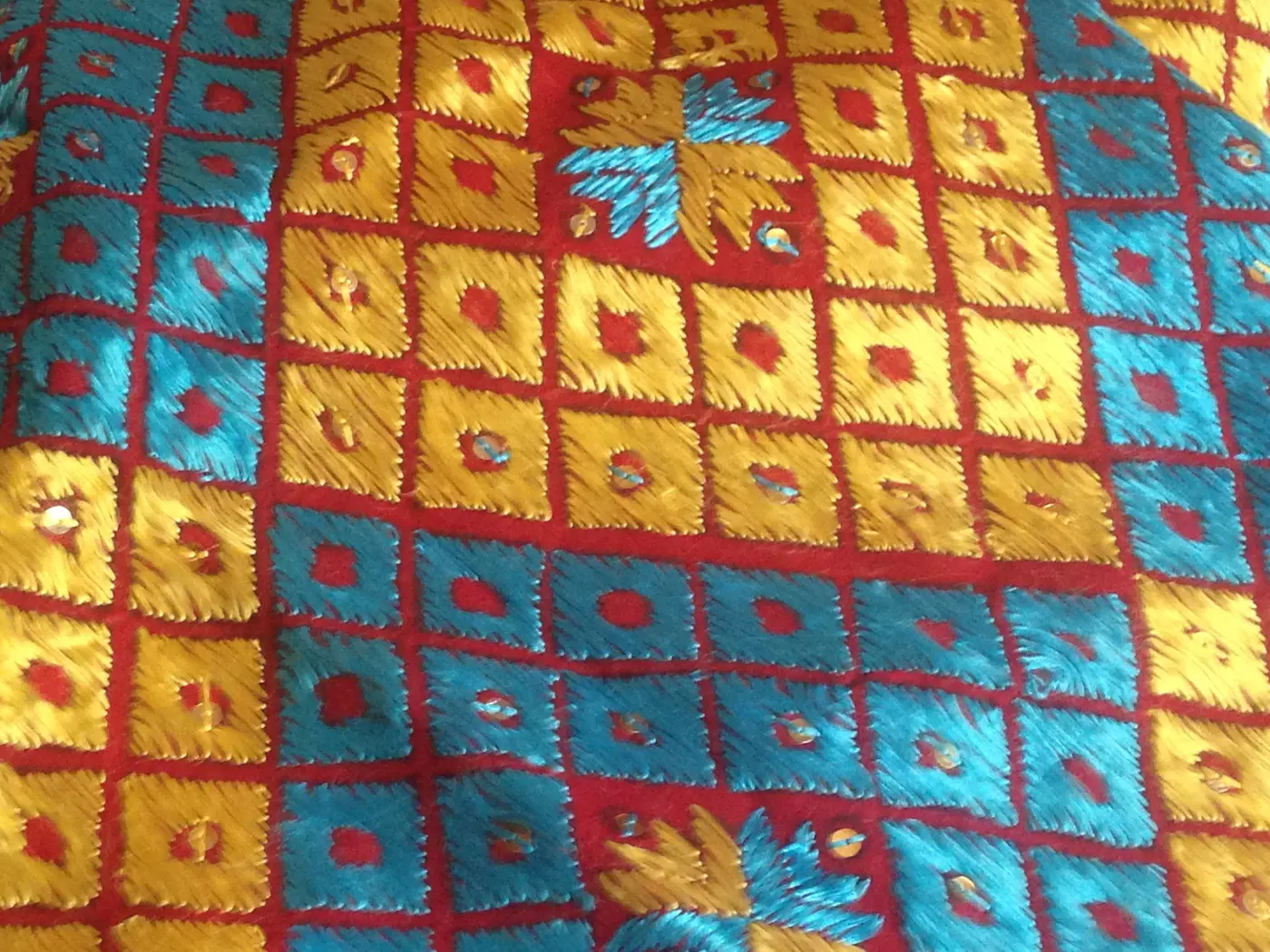 A grid of embroidered squares, each worked in a different counted-thread motif