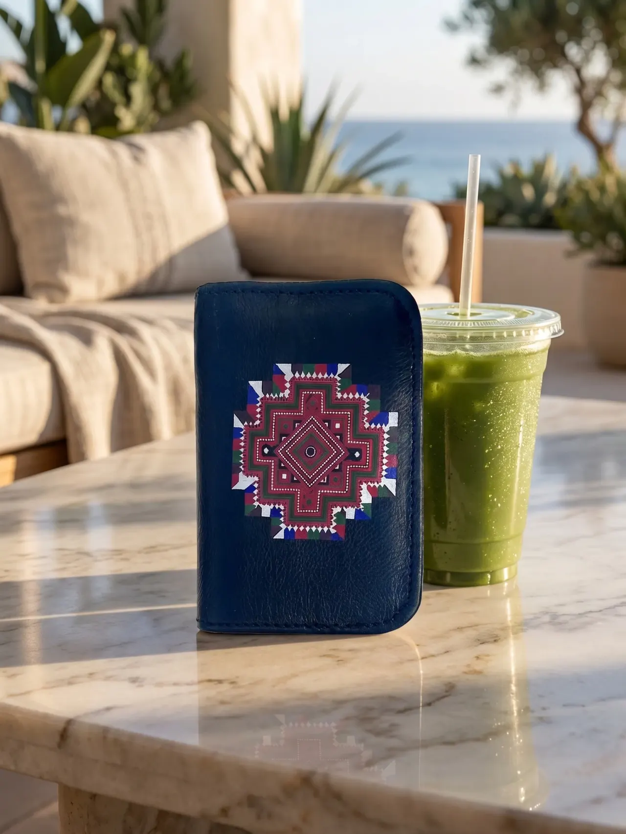 A navy blue leather cardholder with a red, green and white diamond mandala motif